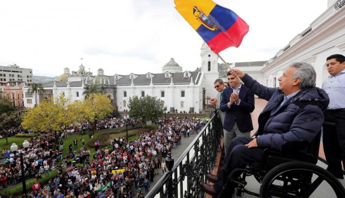 El presidente Lenín Moreno ondeando una bandera nacional desde el balcón del palacio presidencial Carondelet en Quito, el 15 de octubre de 2019.