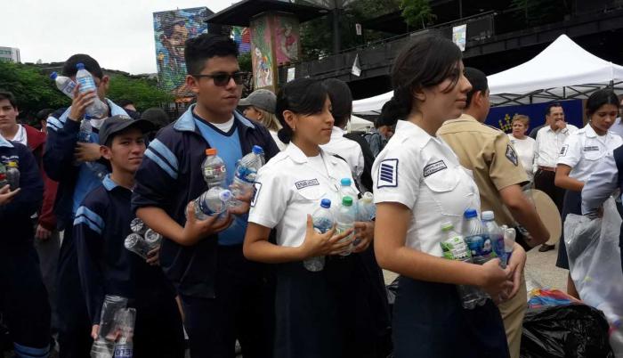 Estudiantes de varios colegios entregan en la feria botellas plásticas que reciclaron en sus planteles.