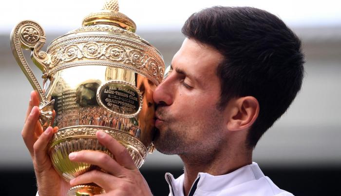 Djokovic besa su trofeo luego de derrotar por tercera vez a Federer en una final de Wimbledon.