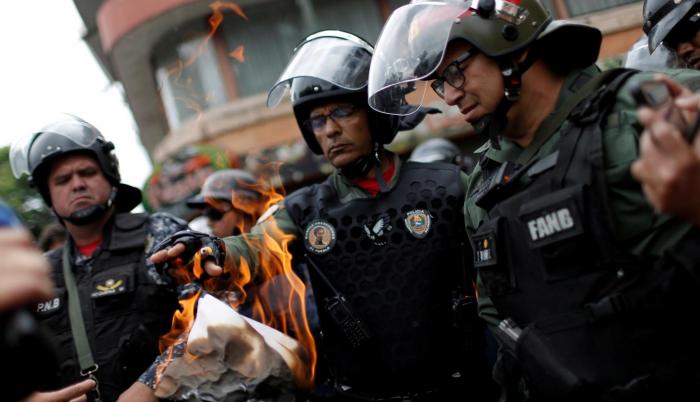 Imagen referencial. Un miembro de la guardia nacional quema un documento que fue entregado por un ciudadano cerca de la base militar de Caracas.