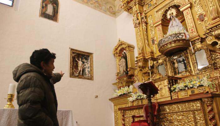 La señora Feliza señala el espacio donde se encuentra San Sebastián. Según la leyenda, esa era la ventana por donde salía Almeida.
