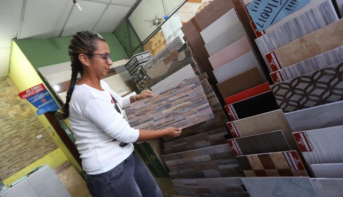 Comercio. Mariana Urbina, administradora del local Braga, muestra las opciones de cerámica para pisos.