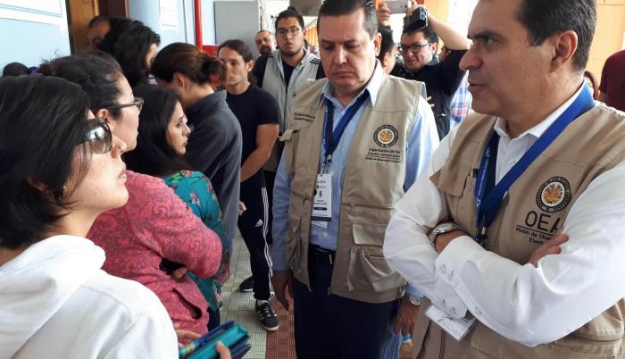El costarricense Kevin Casas (d), habla este domingo con votantes en el colegio Benalcázar, en el norte de Quito (Ecuador).