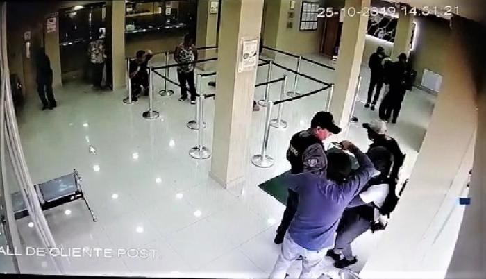 Uno de los delincuentes atacó al guardia de la entidad bancaria.