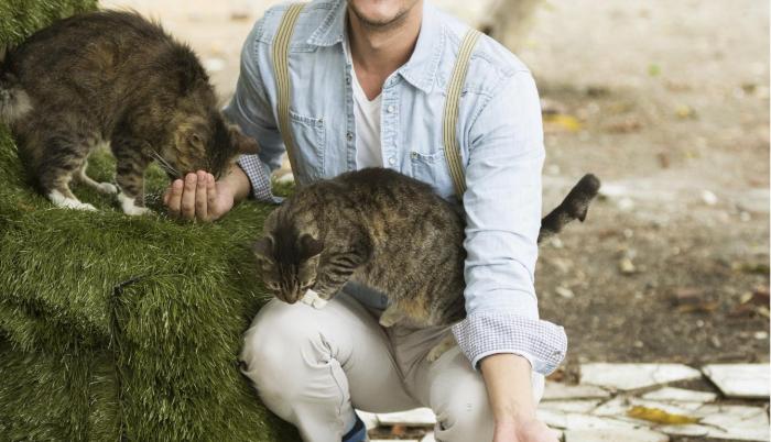 Joshua rodeado de algunos de sus gatos.