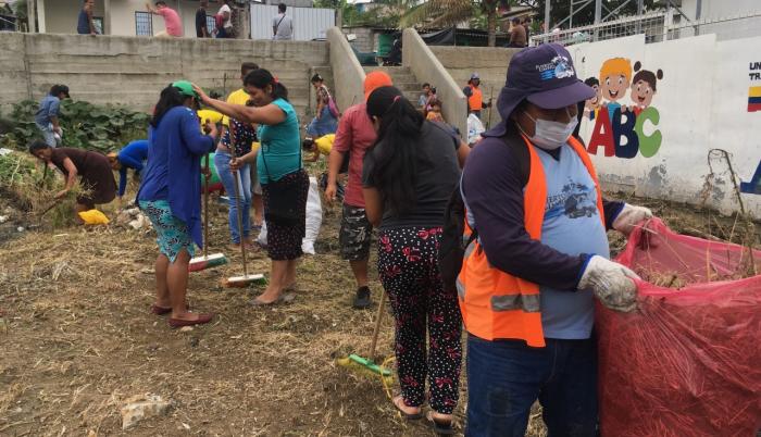 Con ayuda de algunos miembros de Puerto Limpio, padres de familia realizan mingas en los alrededores del plantel educativo.