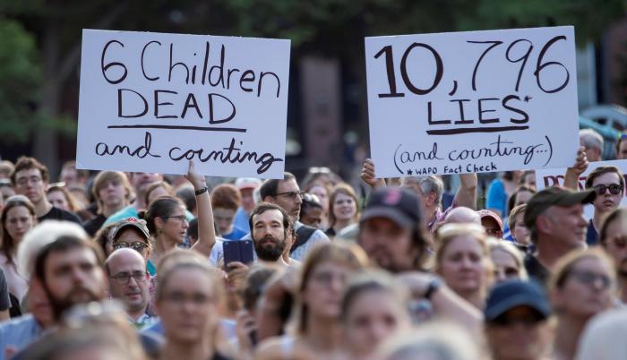 Manifestantes sostuvieron carteles en los que se leen “6 niños muertos y contando” (i) y “10.796 mentiras y contando” (d) durante una manifestación en los exteriores de la Casa Blanca. La protesta del pasado viernes exigió el cierre de los centros de dete
