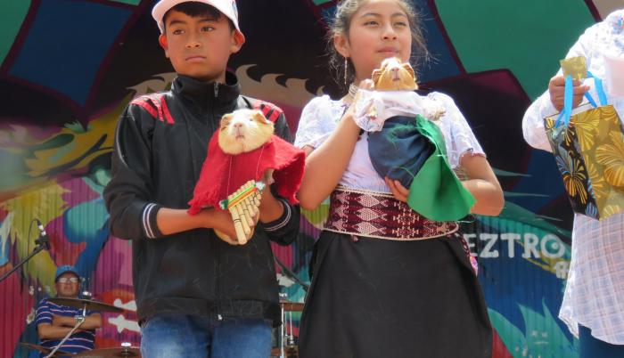 Dos niños con ‘Luisito’ y ‘Carmencita’, los cuyes que ganaron con su vestimenta.