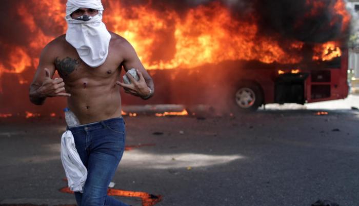Manifestante de la oposición con una piedra, cerca de la base aérea La Carlota, en Caracas.