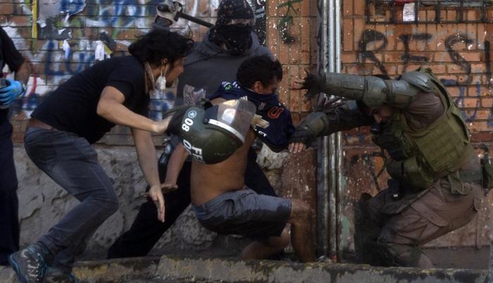 Los manifestantes se enfrentan con la policía antidisturbios durante una protesta contra el gobierno en Santiago el pasado sábado.