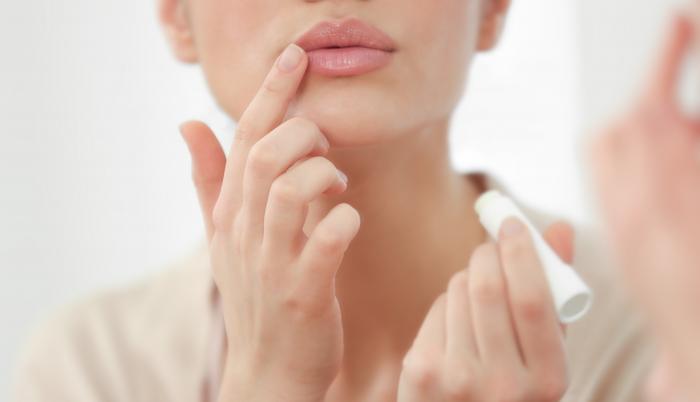 Mujer aplica bálsamo a sus labios