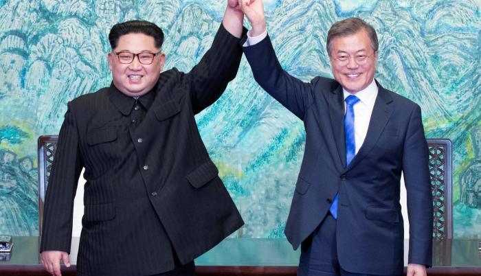 El líder norcoreano Kim Jong-un (i) y el presidente surcoreano, Moon Jae-in (d) se cogen de la mano tras la firma de un documento en el marco de la cumbre intercoreana en la zona de seguridad conjunta (JSA)