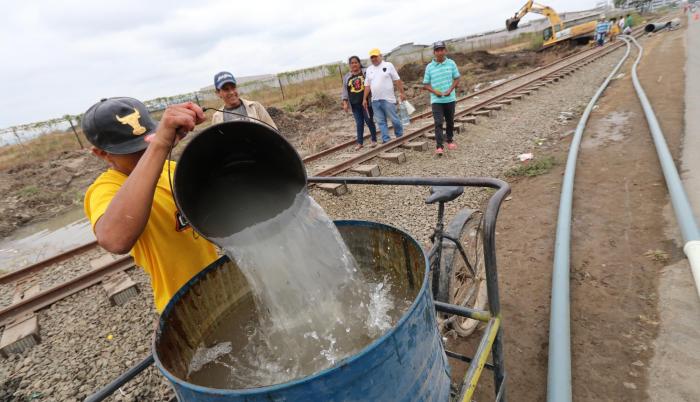 Algunos moradores aprovecharon la rotura de una tubería, a la altura de la cooperativa 28 de Agosto en Durán, para recolectar agua que, aunque sucia, dijeron les servía para trabajar, sobre todo, en el área de construcción.