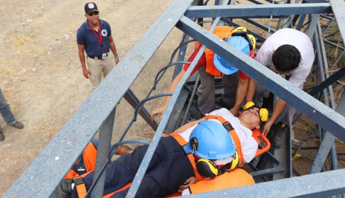 Rescate. En medio del simulacro, el trabajador de una empresa simula quedar atrapado entre unos fierros donde trabaja. Los brigadistas lo rescatan.