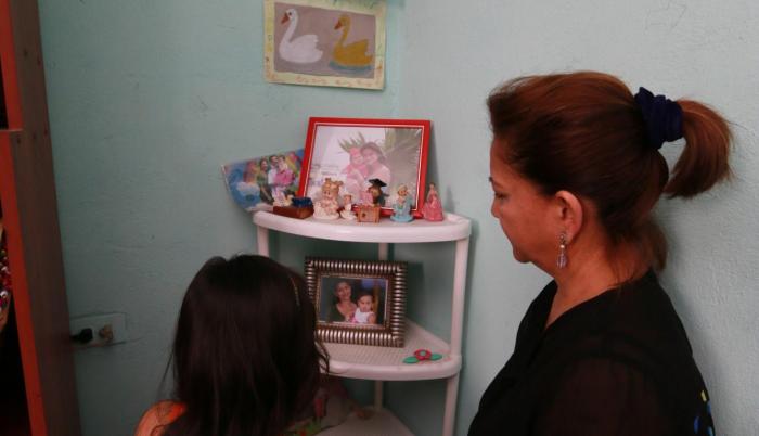 Recuerdos. Vitalia y su nieta miran el altar que la pequeña ha elaborado para su mamá muerta.