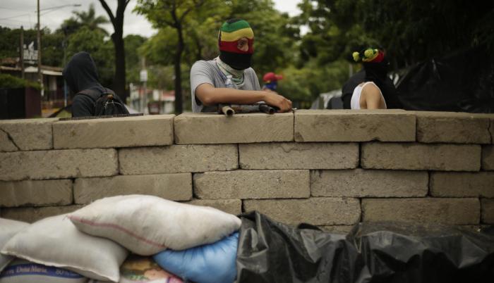 Universidad. Un estudiante vigila una barricada frente a los continuos ataques de la policía antidisturbios.