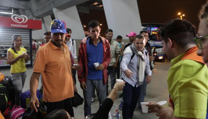 Apoyo. El grupo ‘Sonríe chamo’ da chocolate y pan en la terminal terrestre de Guayaquil.