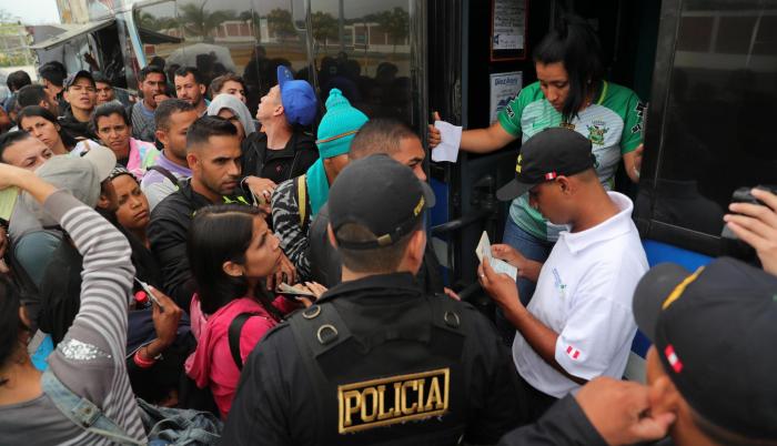 Inmigrantes venezolanos presentan sus documentos al subir a un bus que los llevará a Trujillo desde el Centro Binacional de Atención en Frontera (Cebaf) en Tumbes (Perú).