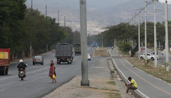 Tráfico. Ante la falta de señalética y paraderos, los habitantes cruzan entre los autos; o esperan a orillas de la ciclovía.