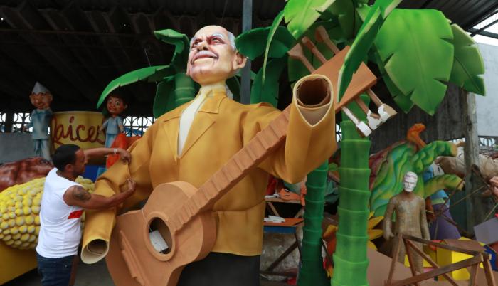 El cantautor. Uno de los artesanos termina de pintar la escultura gigante de un Carlos Rubira Infante, que será parte del desfile.
