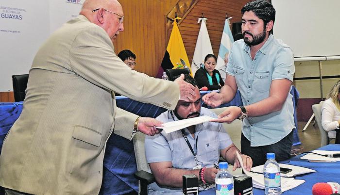 Guayas. Julio Candell (d), director de Procesos Electorales, entrega reportes del sorteo al notario Carlos Alvear.
