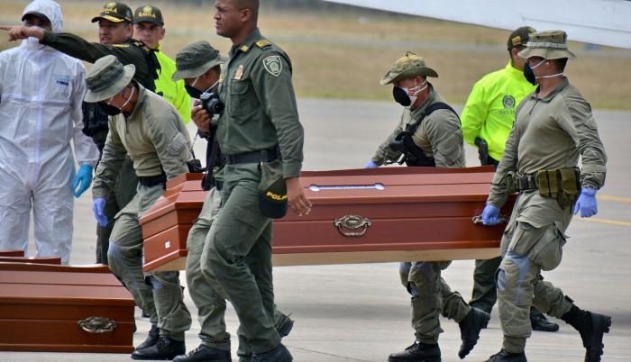 Traslado. Personal militar de Colombia traslada los ataúdes con los restos de los cuerpos encontrados el viernes.