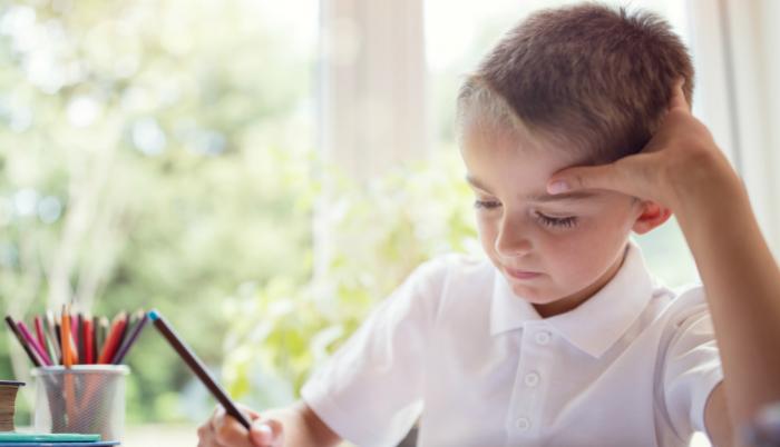 Niño escribiendo en su cuaderno