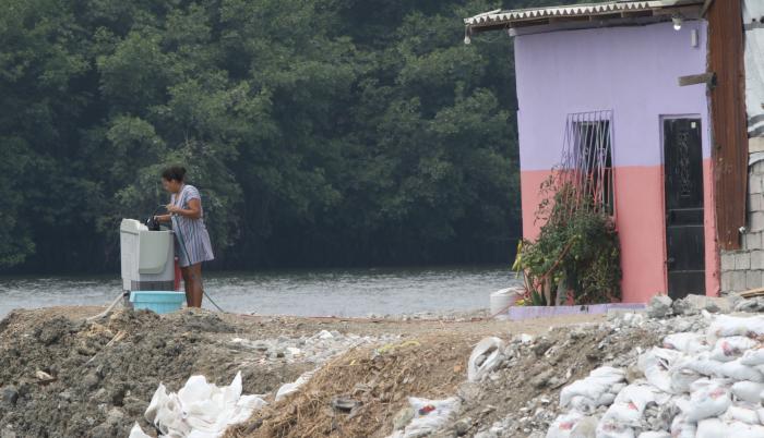 Una lavadora de ropa, junto al brazo de mar y frente al manglar que cubre la zona.