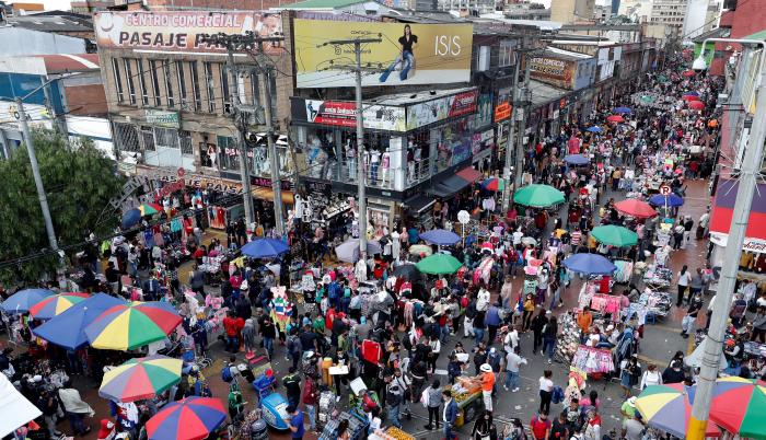 Ciudadanos se aglomeran mientras hacen compras navideñas en el popular sector de San Victorino, en Bogotá (Colombia).