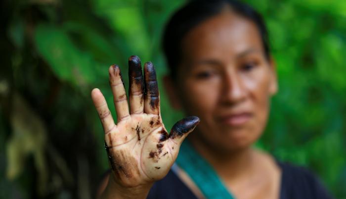 Una indígena de la comunidad de Amarumesa muestra en su mano residuos de petróleo en la Amazonía ecuatoriana.