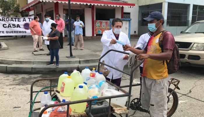 Un habitante del suburbio recibe información sobre el virus.