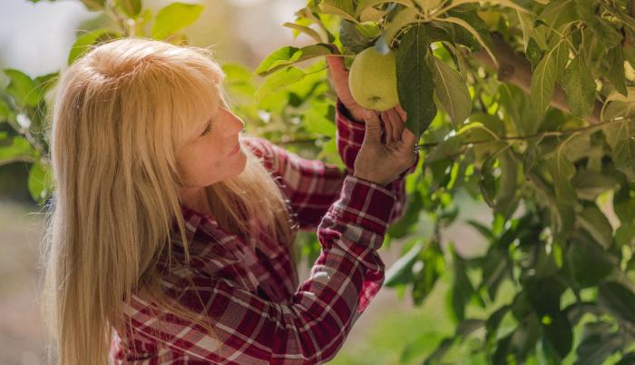 Mujer cogiendo una fruta
