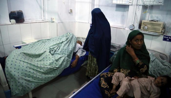 Una mujer recibe atención médica tras resultar herida en uno de los dos asesinatos selectivos perpetrados contra tres presentadoras de televisión afganas que murieron tiroteadas, en Jalalabad.