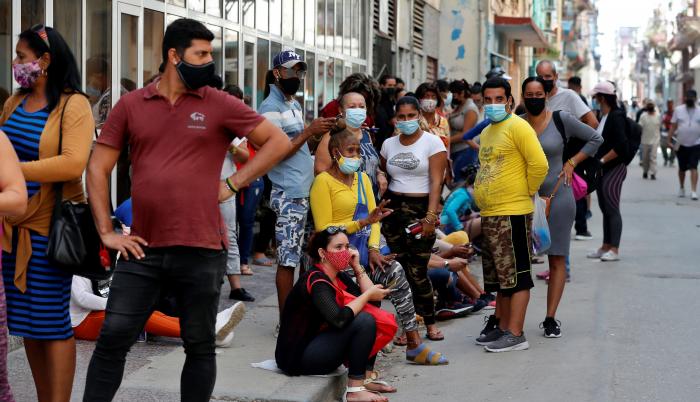 Grupos de personas con tapabocas hacen fila para comprar en un mercado, el 11 de marzo de 2021, en La Habana (Cuba).