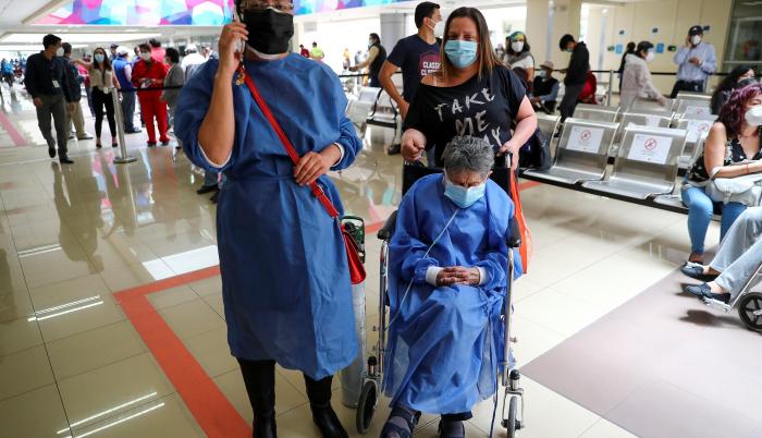 Una adulta mayor espera el 25 de marzo de 2021 para ser vacunada contra la covid-19, acompañada por una familiar en el Hospital Luz Elena Arismendi de Quito (Ecuador).