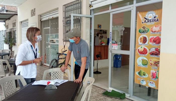 Visita. Funcionaria municipal habla con el administrador de un local.