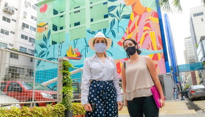 La gerente de la Empresa Pública de Turismo, Gloria Gallardo (i), frente a un mural de la calle Panamá.