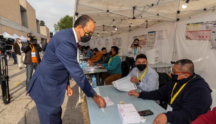 El cónsul de Ecuador en la Región de Murcia Miguel Ángel Macías se registra en la mesa electoral momentos antes de votar, este domingo en el recinto de la Fica en Murcia.