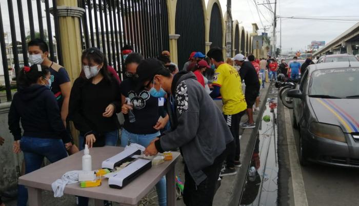 En la medida que llegan más ciudadanos a votar se forman los grupos que buscan plastificar la cédula de votación.