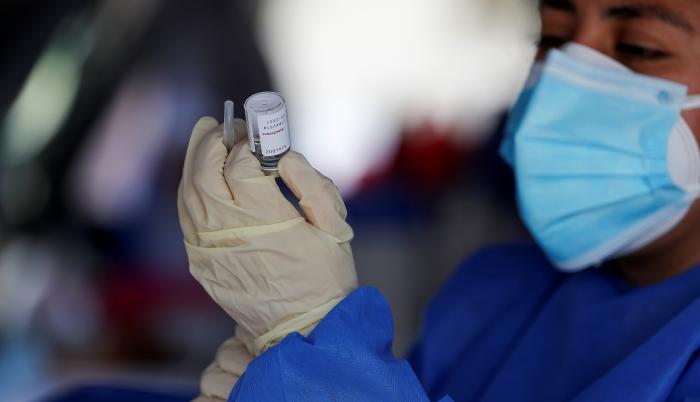 Un miembro del personal de salud sostiene una dosis de la vacuna contra la covid-19 del laboratorio Astrazeneca durante una jornada de vacunación en Quito (Ecuador).