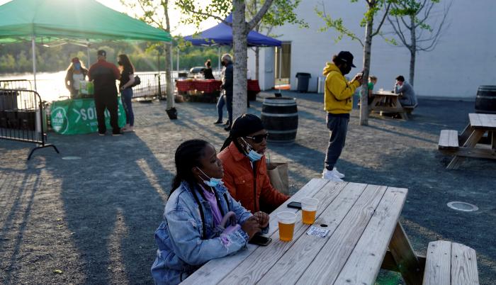 Trabajadores públicos toman una cerveza tras recibir sendas dosis de la vacuna Johnson & Johson contra el coronavirus en el evento