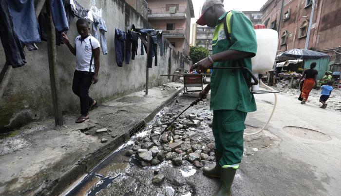 Un empleado del Instituto de Higiene Pública fumiga con insecticida una calle para exterminar mosquitos y prevenir la malaria en Costa de Marfil.