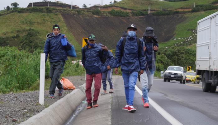 Grupos de migrantes venezolanos caminan por una carretera en la región de Tulcán (Ecuador).