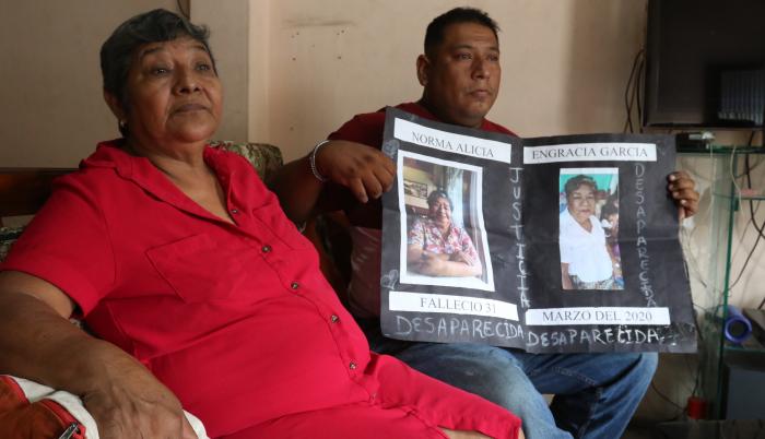 Reclamo. Roberto Farías muestra, junto a su tía, un cartel con la foto de su madre saparecida desde la pandemia.