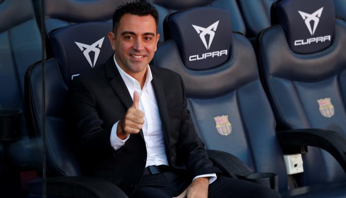 El nuevo entrenador del FC Barcelona, Xavi Hernández, posa en el banquillo del Camp Nou tras finalizar el acto de presentación como entrenador blaugrana.