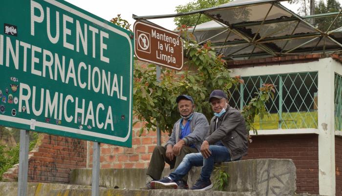 Dos conductores ecuatorianos esperan en el paso de Rumichaca a la devolución de su camión desde Colombia por un conductor de ese país antes de la reapertura de la frontera.