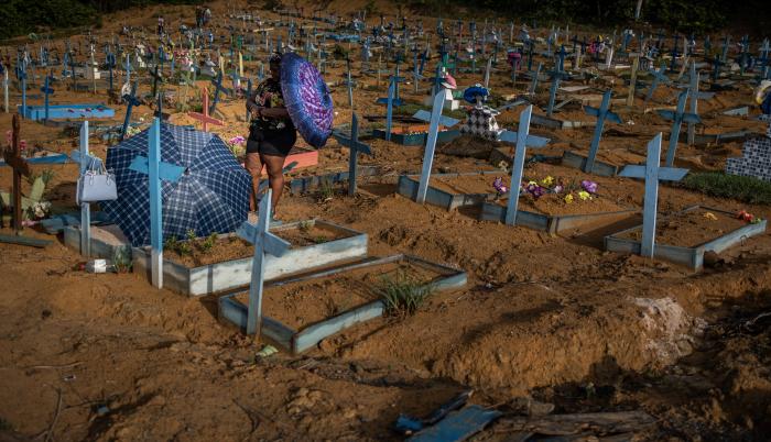 Personas se protegen del sol mientras visitan las tumbas de familiares en el área destinada a las víctimas del Covid-19 en el cementerio Nossa Senhora Aparecida, en Manaos, en una fotografía de archivo.