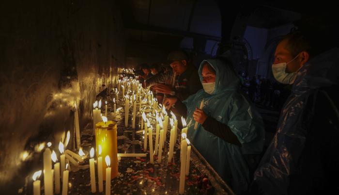 Personas encienden velas en la madrugada de hoy tras realizar la