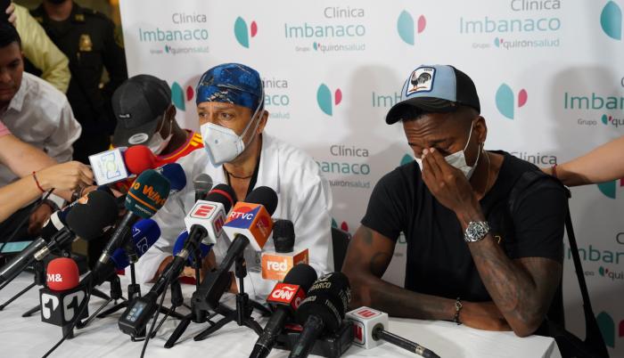 Fotografía cedida hoy por la Alcaldía de Cali que muestra al médico Laureano Quintero (c), director médico de la clínica Imbanaco de Cali, mientras anuncia a los medios de comunicación la muerte del exfutbolista colombiano Fredy Rincón en compañía de sus