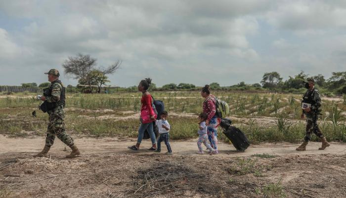 Miembros de la policía de Perú controlan el paso de migrantes venezolanos que intentan cruzar la frontera de Perú por la orilla del río Zarumilla, junto a Ecuador el 6 de mayo de 2022.